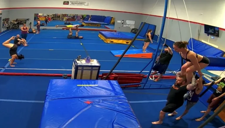 Adult participants working on partner acrobatics together at open gym