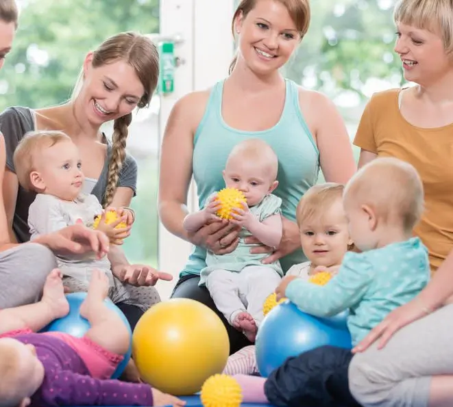 Group of parents and babies together in a parent and baby gymnastics class